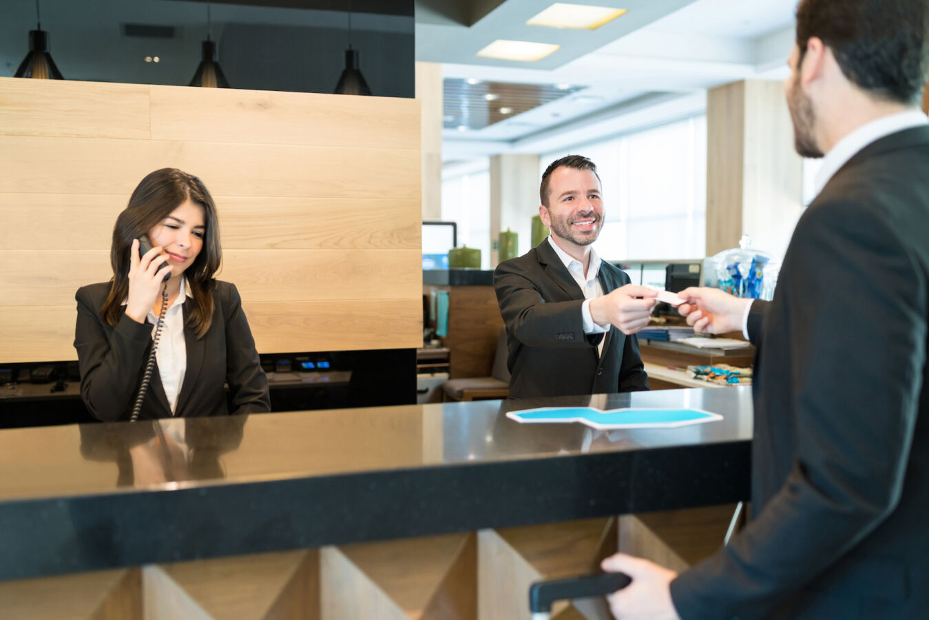 Receptionist Giving Card Key To Businessman At Lobby
